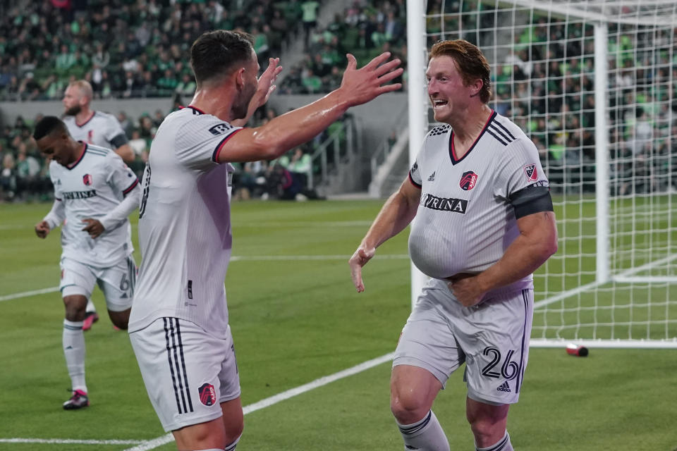 St Louis City FC Tim Parker (26) holds the ball under his jersey as he celebrates his goal against the Austin FC with teammate Eduard Lowen, left, during the first half of an MLS soccer match in Austin, Texas, Saturday, Feb. 25, 2023. (AP Photo/Eric Gay)