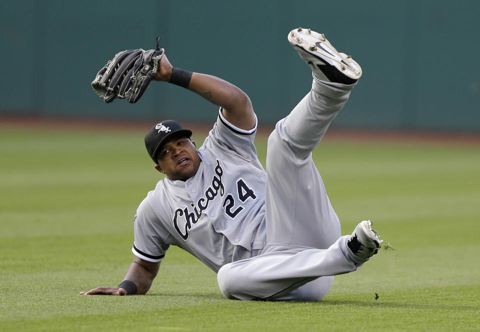 Chicago White Sox's Dayan Viciedo rolls after diving for a ball hit by Cleveland Indians' Lonnie Chisenhall in the third inning of a baseball game, Saturday, May 3, 2014, in Cleveland. Chisenhall was out. (AP Photo/Tony Dejak)