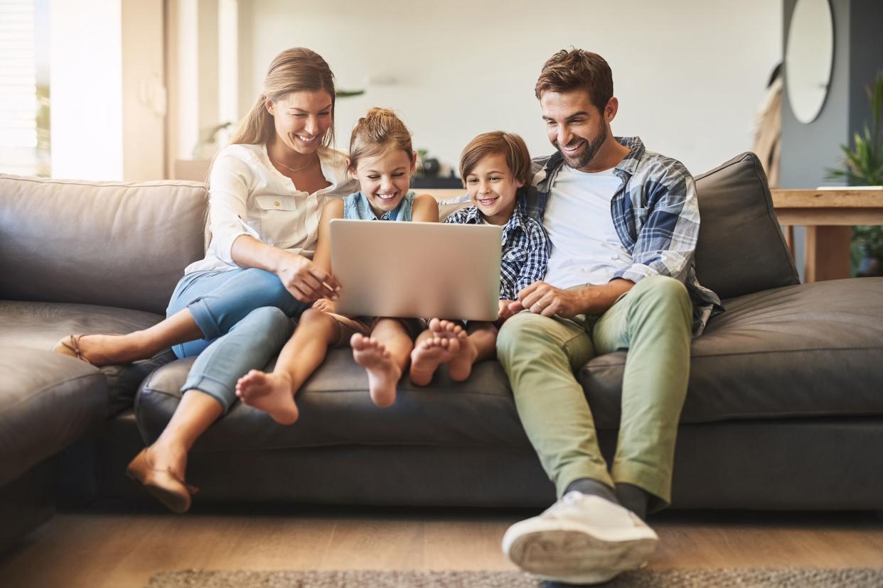 family on couch looking at laptop