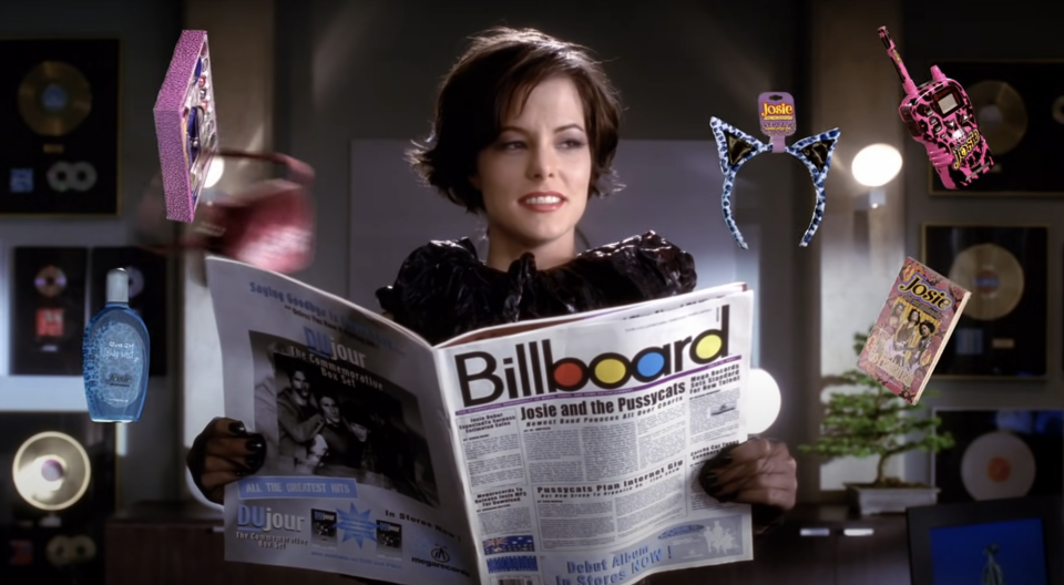 Fiona holding a copy of Billboard with a "Josie and the Pussycats" headline