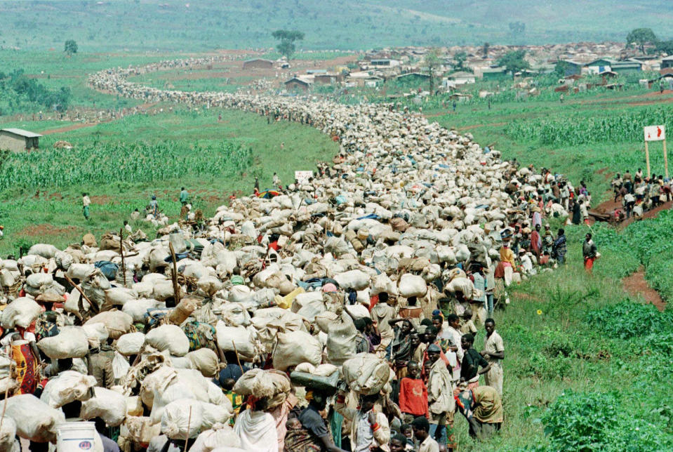 FILE - Tens of thousands of Rwandan refugees, who have been forced by Tanzanian authorities to return to their country despite fears they will be killed upon their return, stream back towards the Rwandan border on a road in Tanzania, on Dec. 19, 1996. A frail 87-year-old Rwandan, Félicien Kabuga, accused of encouraging and bankrolling the 1994 genocide in his home country goes on trial Thursday, Sept. 29, 2022, at a United Nations tribunal, nearly three decades after the 100-day massacre that left 800,000 dead. (AP Photo/Jean-Marc Bouju, File)