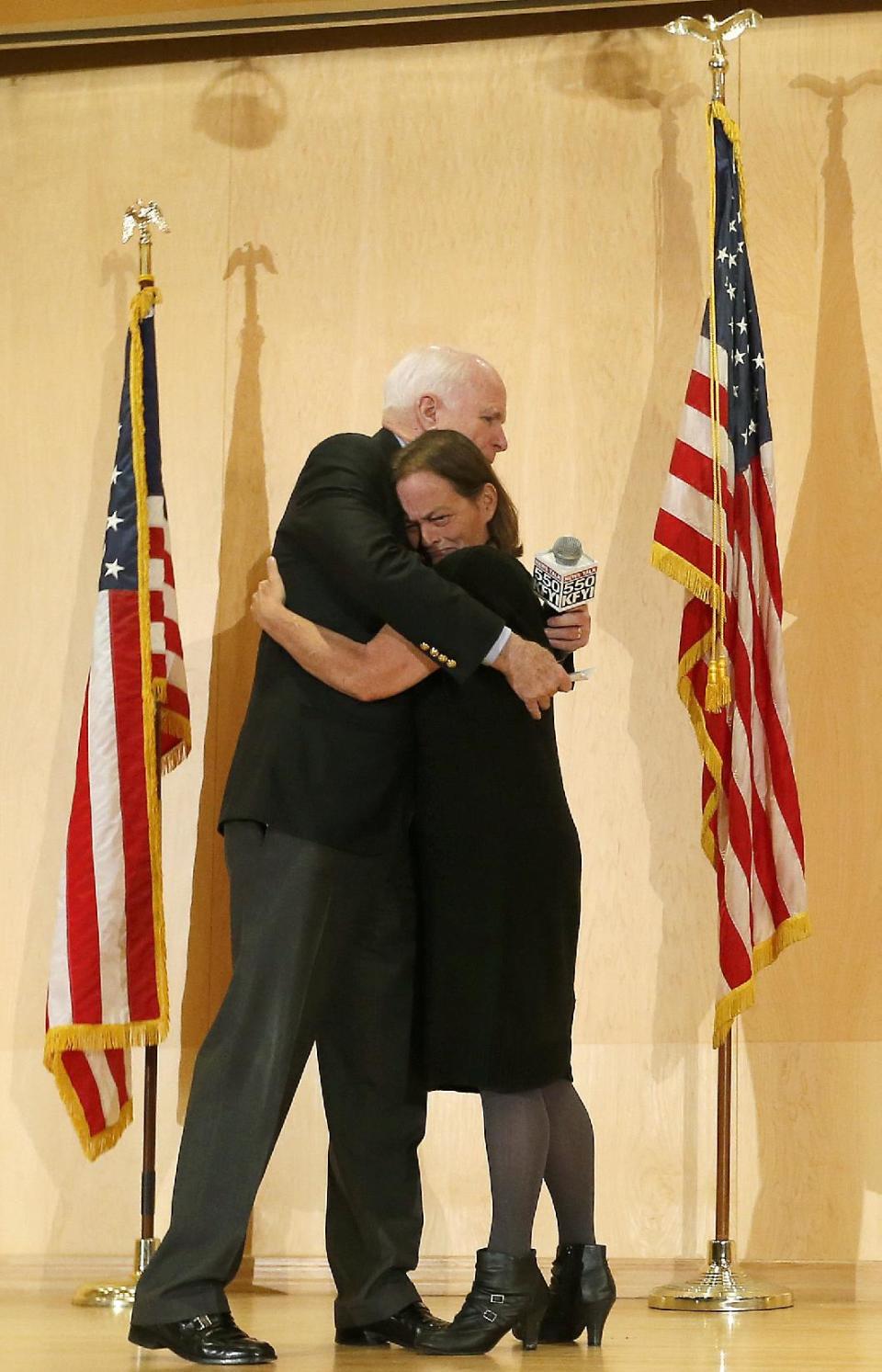 Sen. John McCain embraces Gabriel Basso after she shared how her veteran husband died during a forum with veterans on Friday, May 9, 2014, in Phoenix. McCain was discussing lapses in care at the Phoenix Veterans Affairs hospital that prompted a national review of operations around the country. (AP Photo/Matt York)