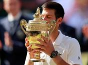 Tennis - Wimbledon - All England Lawn Tennis and Croquet Club, London, Britain - July 15, 2018 Serbia's Novak Djokovic celebrates with the trophy after winning the men's singles final against South Africa's Kevin Anderson. REUTERS/Andrew Couldridge