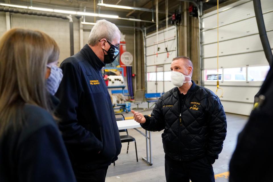 Jan 17, 2022; Passaic, NJ, Passaic; (from left) First lady Tammy Murphy and New Jersey Gov. Phil Murphy speak to Passaic Battalion Chief John Hayowyk at the Eastside firehouse on Monday. Hayowyk was one of the first on the scene of the 11-alarm fire that decimated a warehouse and part of a chemical plant on Friday, Jan. 14. Mandatory Credit: Danielle Parhizkaran/NorthJersey.com