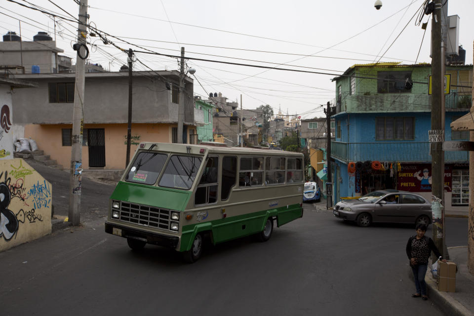 En esta fotografía del 15 de mayo de 2019, un camión del transporte público pasa por el vecindario de San Miguel Teotongo, en la Ciudad de México. (AP Foto/Rebecca Blackwell)