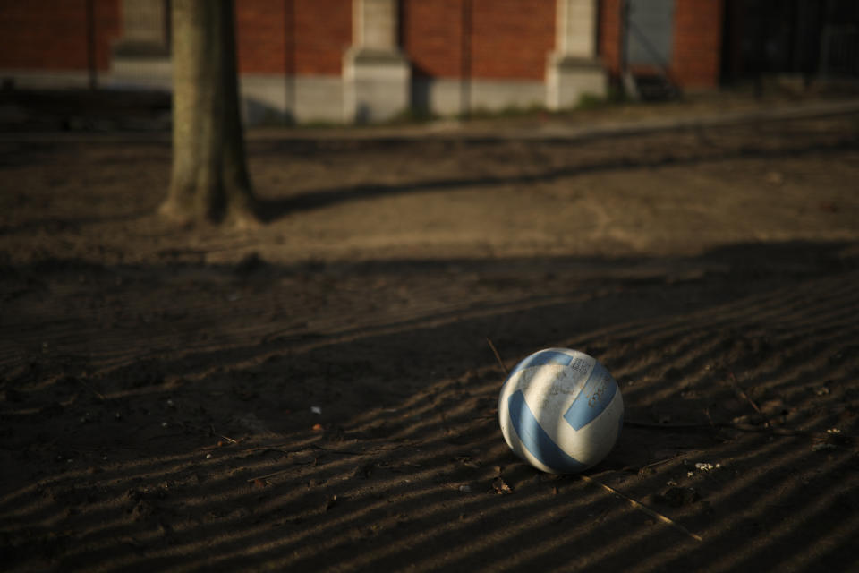 A soccer ball lays on the playground of a closed primary school in Brussels, Thursday, March 19, 2020. Belgium has ordered further lockdown measures following in the steps of European neighbours Italy, Spain and France. For most people, the new coronavirus causes only mild or moderate symptoms, such as fever and cough. For some, especially older adults and people with existing health problems, it can cause more severe illness, including pneumonia. (AP Photo/Francisco Seco)