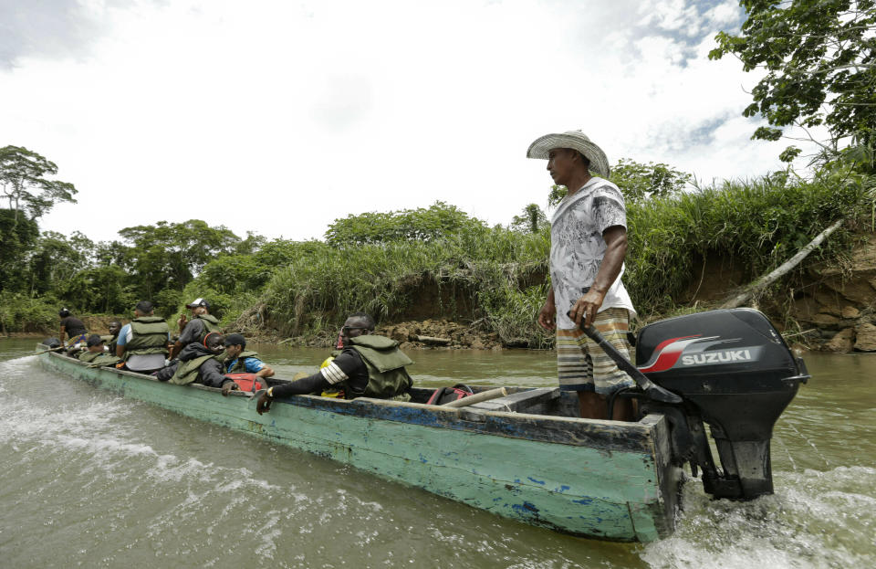 En esta imagen, tomada el 25 de mayo de 2019, migrantes viajan en un barco sobrecargado por el Río Tuquesa hacia Peñitas, desde Bajo Chiquito, en la provincia de Darién, Panamá. Los pilotos de las embarcaciones suelen levantar sus motores fueraborda para evitar que choquen contra el lecho del río, poco profundo y lleno de rocas, y se alejan de la orilla para buscar aguas más profundas y esquivar los troncos arrancados en inundaciones previas. (AP Foto/Arnulfo Franco)