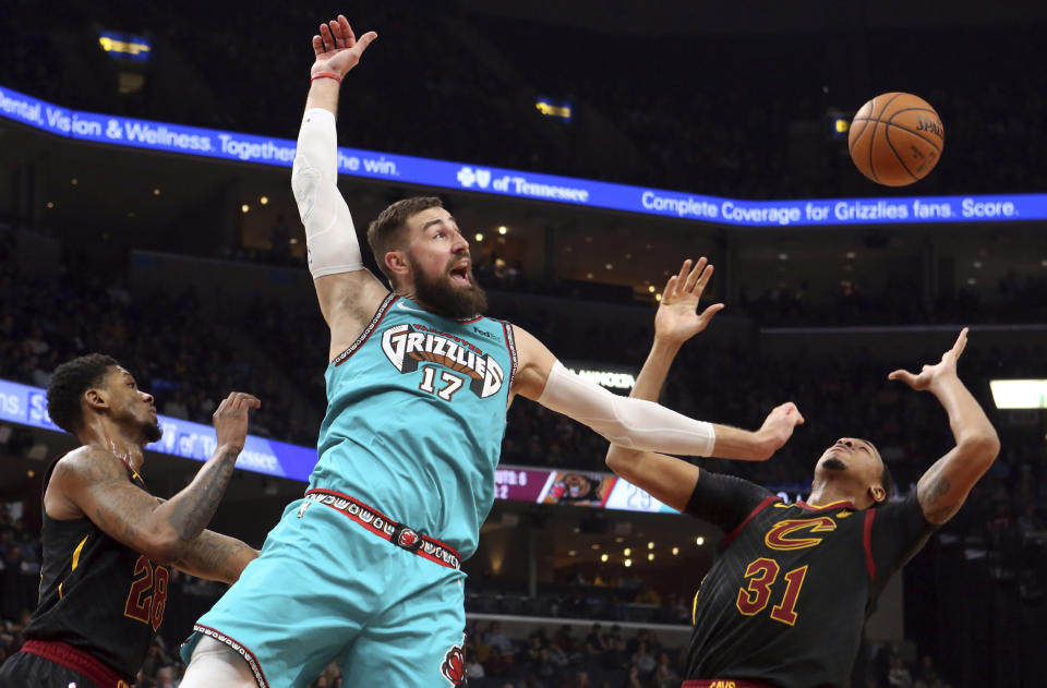 Memphis Grizzlies center Jonas Valanciunas (17)) and Cleveland Cavaliers forward John Henson (31) look for a rebound during the first half of an NBA basketball game Friday, Jan. 17, 2020, in Memphis, Tenn. (AP Photo/Karen Pulfer Focht)