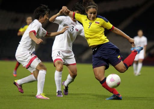 North Korea's Kim Nam Hui (L) vies with Colombia's Orianica Velasquez (R) during the Women's Olympic football match North Korea vs Colombia at Hampden Park, in Glasgow, Scotland. North Korea's women's football team refused to take the field for more than an hour Wednesday in protest at an embarrassing mix-up of their national flag on day one of the London Olympics