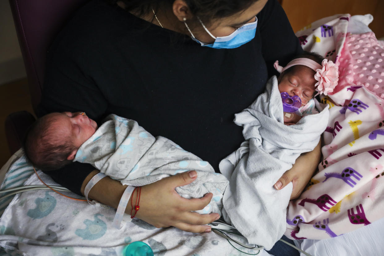 BOSTON, MA - MAY 13: Lisseth Hernandez holds her twins Sebastian Guevara Hernandez, left, and Aurora Guevara Hernandez while visiting them in the NICU at Tufts Medical Center in Boston on May 13, 2020. Hernandez was 29 weeks pregnant and carrying twins when she became severely ill with COVID-19. In danger of dying, doctors at MGH raced to deliver the twins while Lisseth remained on a ventilator. One month later, Lisseth has recovered and her now son and daughter are growing bigger by the day. (Photo by Erin Clark/The Boston Globe via Getty Images)
