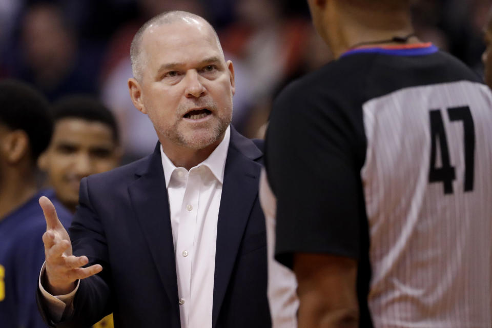 Denver Nuggets head coach Michael Malone talks with referee Bennie Adams (47) during the first half of an NBA preseason basketball game against the Phoenix Suns, Monday, Oct. 14, 2019, in Phoenix. (AP Photo/Matt York)