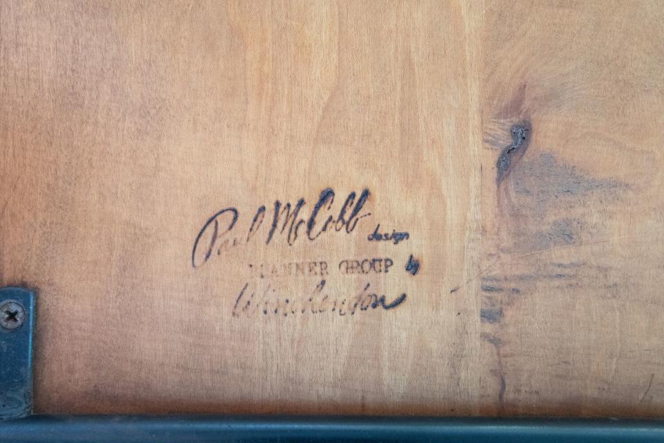 The heat brand on a piece of wood bears the signature "Paul McCobb: Planner Group."