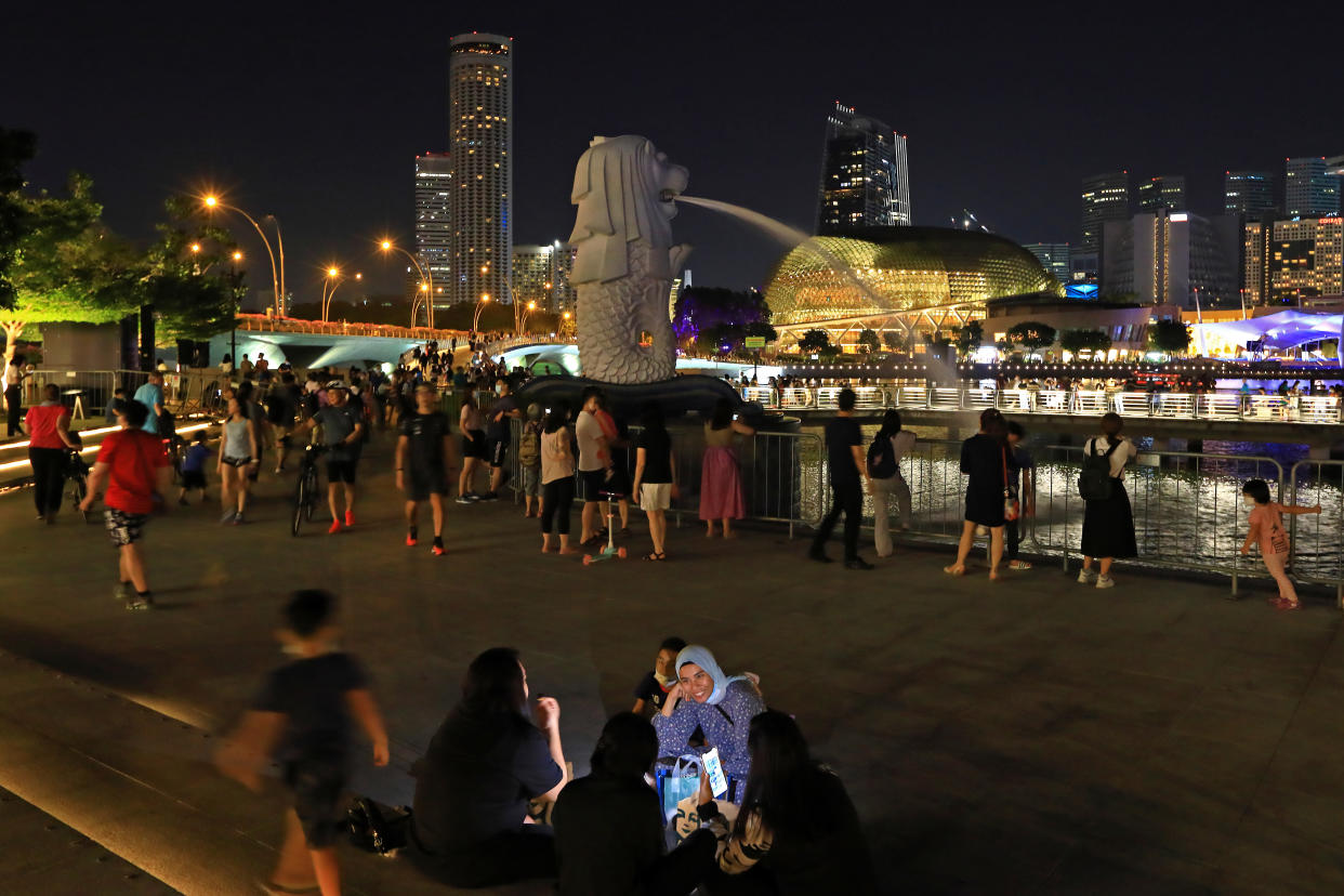 People spend a night out at the Merlion Park on December 28, 2021 in Singapore. (Photo by Suhaimi Abdullah/NurPhoto via Getty Images)