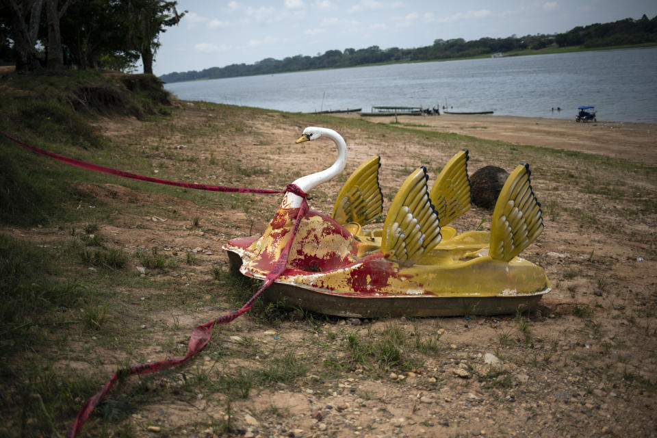 A rental pedal boat sits idle on the banks of the Yarinacocha Lagoon, in Peru's Ucayali region, Thursday, Oct. 8, 2020. The Ucayali region located along a muddy river has long seen periodic dengue outbreaks, though this year's figures are already three times that seen in 2019. (AP Photo/Rodrigo Abd)