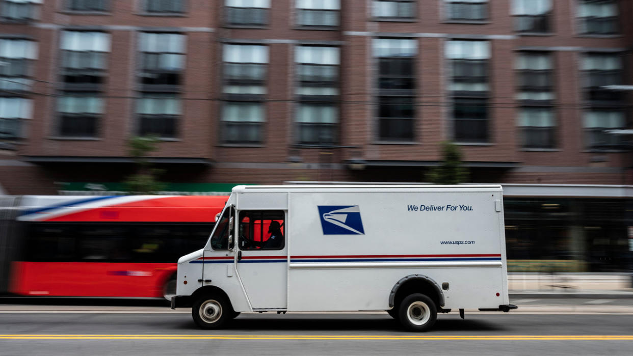 A postman drives a United States Postal Service mail delivery truck through Washington, D.C.