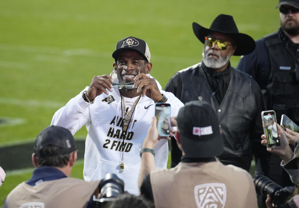 Colorado head coach Deion Sanders, center, puts on his sunglasses after acknowledging the crowd before an NCAA college football game against Colorado State, Saturday, Sept. 16, 2023, in Boulder, Colo. (AP Photo/David Zalubowski)