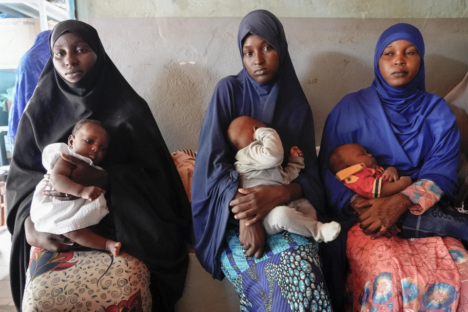 Women gather at a clinic to have their children vaccinated in Niamey, Niger, Monday, Aug. 21, 2023. Severe economic and travel sanctions imposed by the West African regional bloc ECOWAS after mutinous soldiers ousted the country's democratically elected president in July, are taking a toll on Nigeriens and causing concern for health workers. (AP Photo/Sam Mednick)