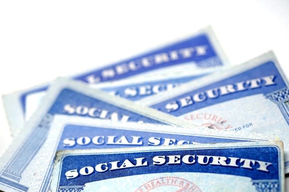 A small pile of Social Security cards messily stacked on each other.