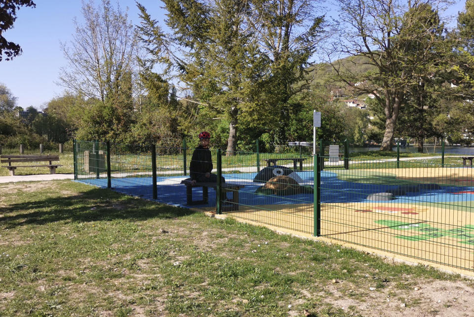 Mohammed, a 14-year-old with autism, sits at a play ground outside his home Wednesday April 15, 2020 in Mantes-la-Jolie, west of Paris. France's confinement measures provide an exception for people with autism that allows them to go out in places where they are accustomed to. Coronavirus lockdown is proving an ordeal for kids with disabilities and their families who are having to care for them at home because special schools have been shut down to curb infections. (Courtesy of family via AP)