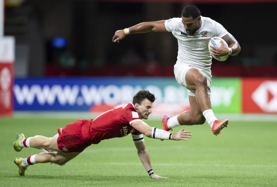 United States' Martin Iosefo, right, leaps past Canada's Andrew Coe and runs the ball for a try during an HSBC Canada Sevens rugby game in Vancouver, British Columbia, Saturday, Sept. 18, 2021. (Darryl Dyck/The Canadian Press via AP)