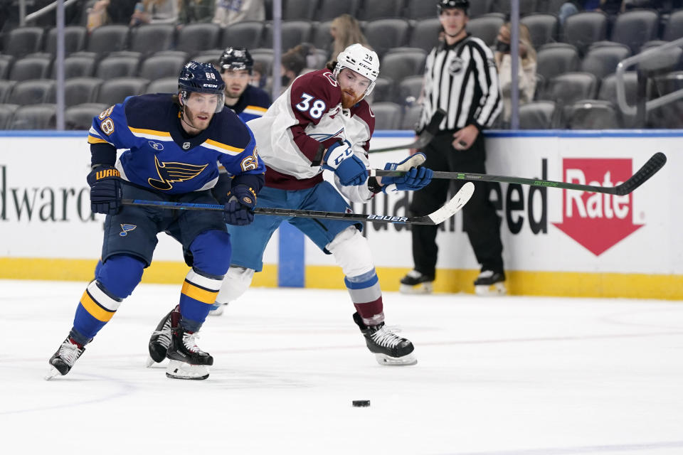 St. Louis Blues' Mike Hoffman (68) and Colorado Avalanche's Liam O'Brien (38) chase after a loose puck during the first period of an NHL hockey game Monday, April 26, 2021, in St. Louis. (AP Photo/Jeff Roberson)