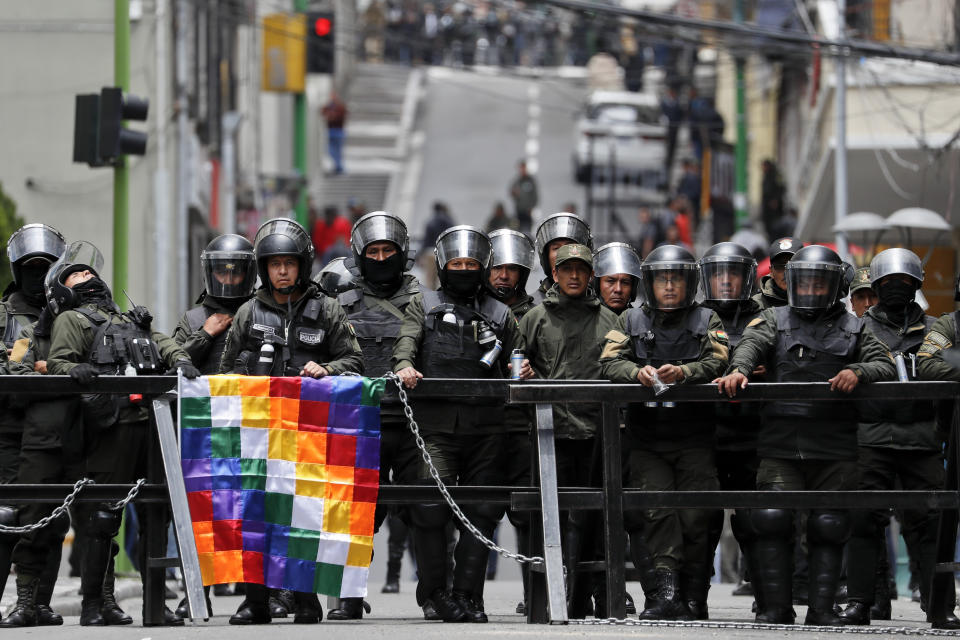 Police block the way to the presidential palace during a march of backers of former President Evo Morales in La Paz, Bolivia, Wednesday, Nov. 13, 2019. Bolivia's new interim president Jeanine Anez faces the challenge of stabilizing the nation and organizing national elections within three months at a time of political disputes that pushed Morales to fly off to self-exile in Mexico after 14 years in power. (AP Photo/Natacha Pisarenko)