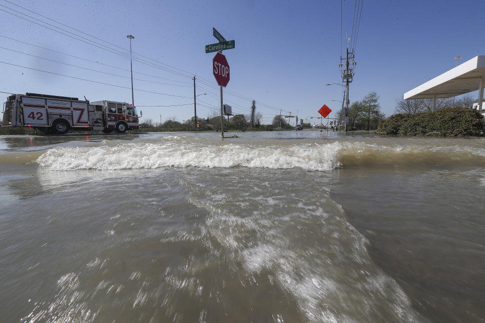 Water rushes by a gas station at Clinton and N. Carolina after a broken water pipe starting flooding of the East Loop 610 Thursday, Feb. 27, 2020, in Houston. (Steve Gonzales/Houston Chronicle via AP)