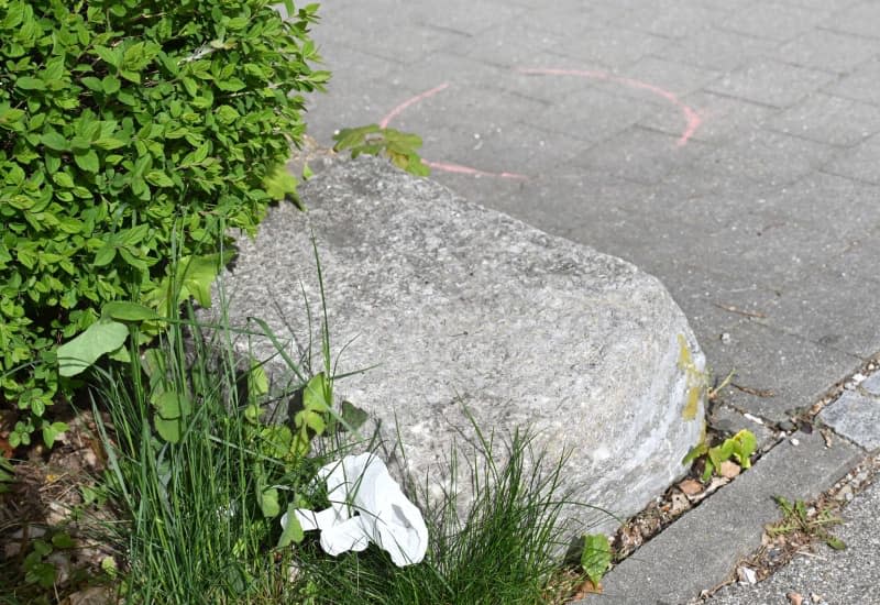 Police markings and a first aid glove pictured on the ground on the site of a shopping center where two men from Ukraine were killed on 27 April. Shortly afterwards, the police were able to arrest a man who is considered an urgent suspect. He is a 57-year-old Russian. Angelika Warmuth/dpa