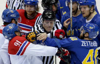 A linesman breaks up a scuffle between Czech Republic forward Martin Erat (91) and Sweden forward Henrik Zetterberg in the third period of a men's ice hockey game at the 2014 Winter Olympics, Wednesday, Feb. 12, 2014, in Sochi, Russia. (AP Photo/Julio Cortez)