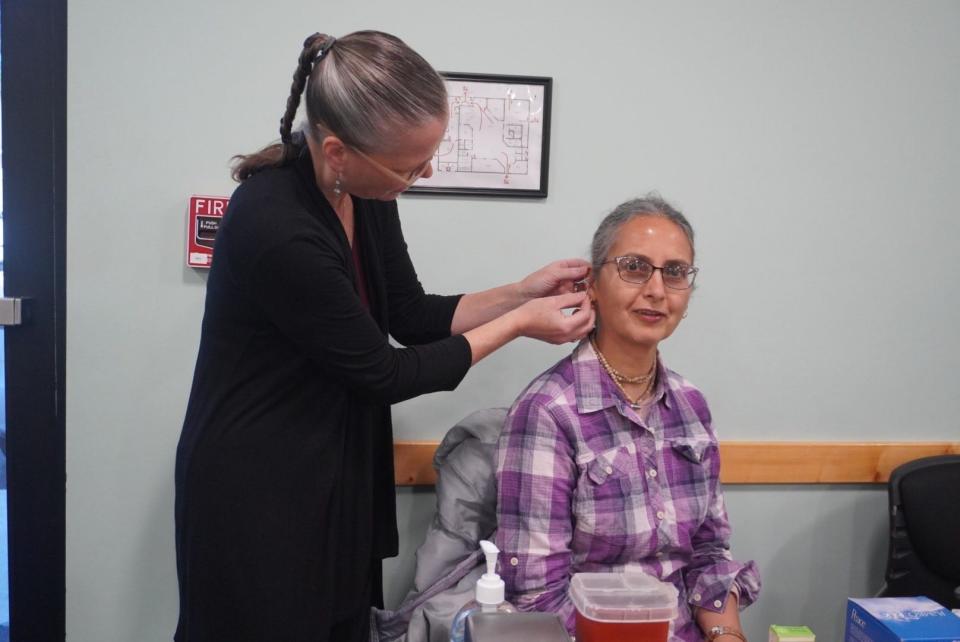 Jennifer Downey, left, helps Swama Mayi, right, during an acupuncture procedure during the American Universal Medicine’s Institute of Energetic Medicine's Community Health and Healing Fair on Saturday at the Library Partnership at 912 NE 16th Ave.