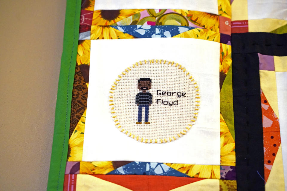 A portrait of the late George Floyd is among the 116 cross-stitched images adorning one of two hand crafted quilts honoring African Americans who lost their lives to racial violence, as part of the Stitch Their Name Memorial Project, on display at the Margaret Walker Center at Jackson State, Tuesday, Nov. 30, 2021, in Jackson, Miss. (AP Photo/Rogelio V. Solis)