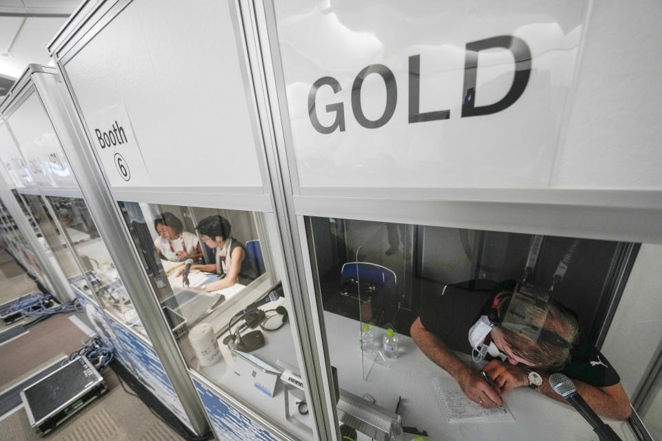 Interpreters work at the main press center during the 2020 Summer Olympics, Friday, July 30, 2021, in Tokyo, Japan. Unlike previous Olympics, all the interpretation is being done remotely with most interpreters working in booths at the main center. Their simultaneous translation can be accessed at all Olympic venues on an app. This eliminates interpreters getting tied up in traffic heading to an venue. (AP Photo/Luca Bruno)