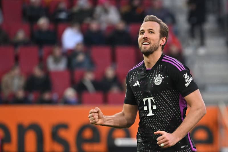 Bayern Munich's Harry Kane celebrates after scoring his side's third goal of the game during the German Bundesliga soccer match between FC Augsburg and Bayern Munich at the WWK-Arena. Sven Hoppe/dpa
