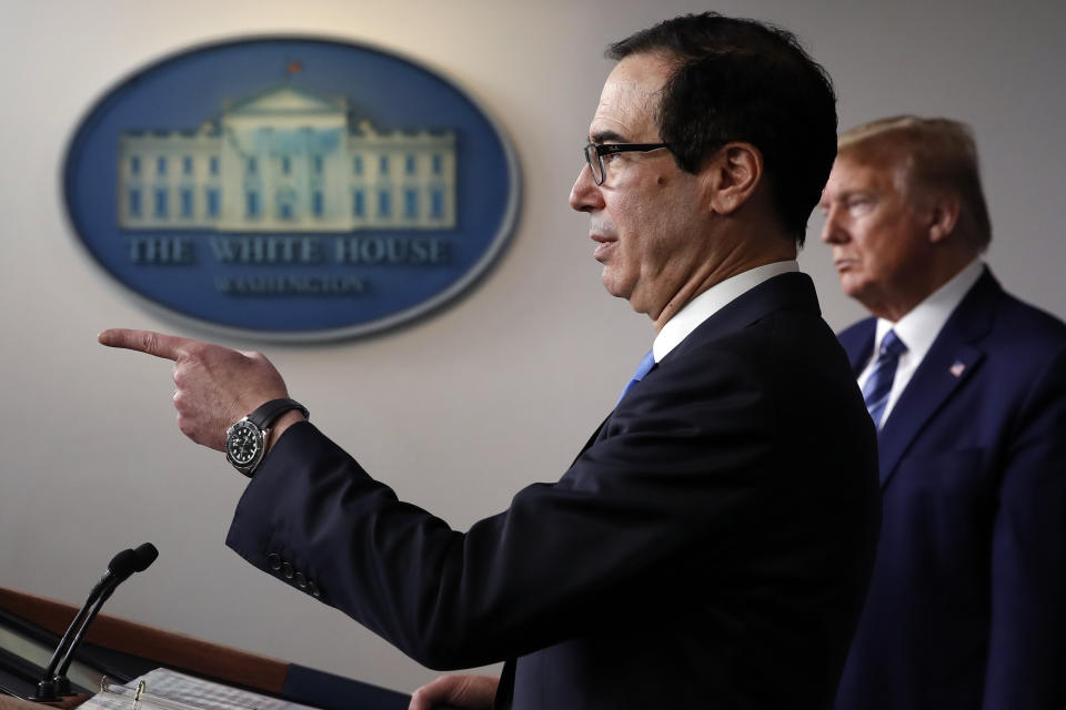 President Donald Trump listens as Treasury Secretary Steven Mnuchin speaks about the coronavirus in the James Brady Press Briefing Room of the White House, Tuesday, April 21, 2020, in Washington. (AP Photo/Alex Brandon)