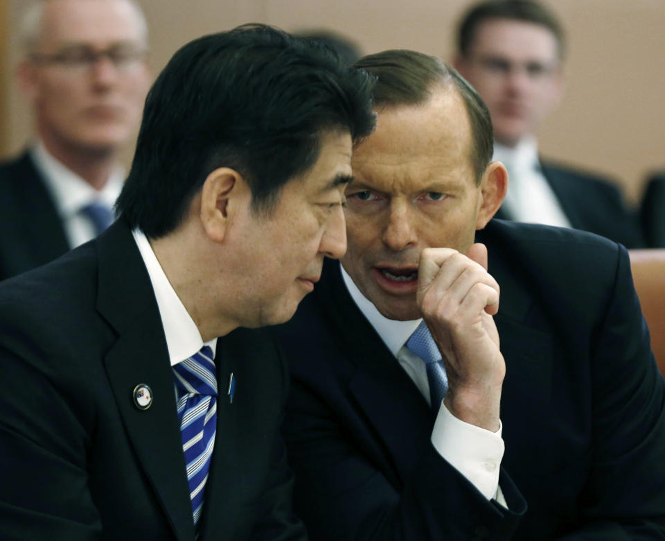 FILE - Japan's Prime Minister Shinzo Abe, left, listens to Australian Prime Minister Tony Abbott during a meeting with members of Abbott's cabinet on national security at Parliament House in Canberra, Australia, on July 8, 2014. Australia will be represented by its government leader plus three former leaders at Abe’s state funeral this month in an extraordinary mark of respect for Japan’s longest-serving prime minister. Prime Minister Anthony Albanese said on Thursday, Sept. 8, 2022, that former Prime Ministers Abbott, John Howard and Malcolm Turnbull would join Australia’s official delegation. (Jason Reed/Pool Photo via AP, File)