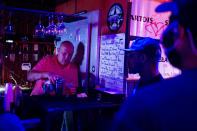 FILE - In this June 8, 2020, file photo, Rodney Ott, owner of The Loft, makes mixed drinks from behind the bar for patrons as he reopens fully for the first time amid the coronavirus outbreak in downtown Flint, Mich. Authorities are closing honky tonks, bars and other drinking establishments in some parts of the U.S. to stem the surge of COVID-19 infections — a move backed by sound science about risk factors that go beyond wearing or not wearing masks. (Jake May/The Flint Journal via AP, File)