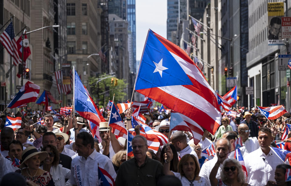 Hundreds of flags of Puerto Rico fly above people taking part in the National Puerto Rican Day Parade Sunday, June 9, 2019, in New York. (AP Photo/Craig Ruttle)