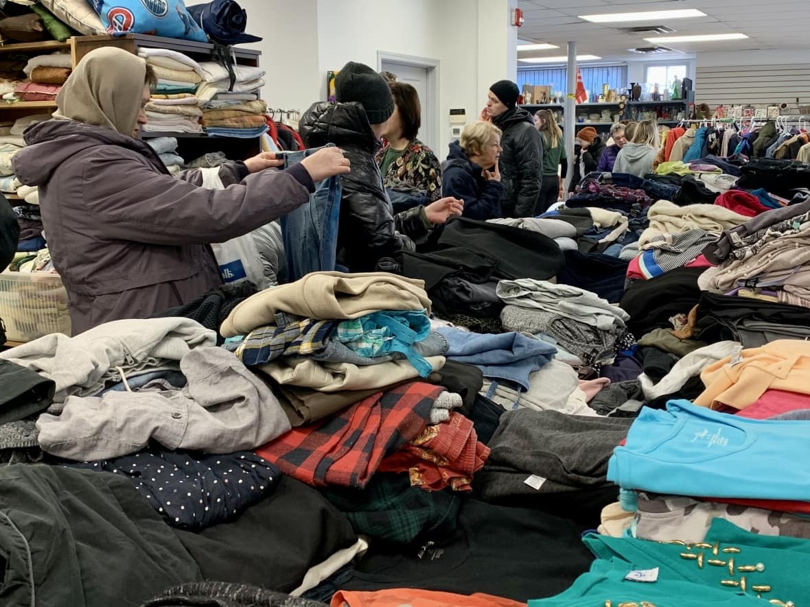 Shoppers browse through donations at the Free Store for Ukrainian Newcomers. As the store name states, there is no charge.  (Adrienne Lamb/CBC - image credit)