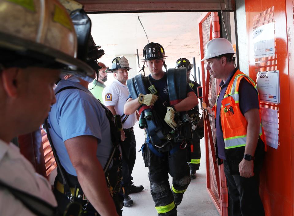 New Rochelle firefighters load equipment onto a construction elevator as they ride up to the top floors of a high-rise under construction at 500 Main Street in downtown New Rochelle Aug. 1, 2023. 