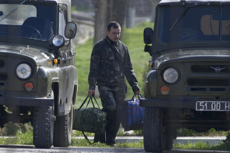 A Ukrainian air force officer carries his bags at the Belbek airbase, outside Sevastopol, Crimea, on Thursday, March 20, 2014. With thousands of Ukrainian soldiers and sailors trapped on military bases, surrounded by heavily armed Russian forces and pro-Russia militia, the Kiev government said it was drawing up plans to evacuate its outnumbered troops from Crimea back to the mainland and would seek U.N. support to turn the peninsula into a demilitarized zone. (AP Photo/Ivan Sekretarev)