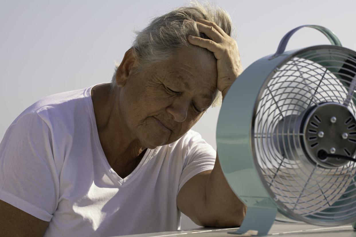 Low-income residents are among those most likely to lose cooling in their homes because they can't pay their bills. <a href="https://www.gettyimages.com/detail/photo/elderly-woman-with-fan-royalty-free-image/1420571004" rel="nofollow noopener" target="_blank" data-ylk="slk:Solidcolours/iStock/Getty Images Plus;elm:context_link;itc:0;sec:content-canvas" class="link ">Solidcolours/iStock/Getty Images Plus</a>