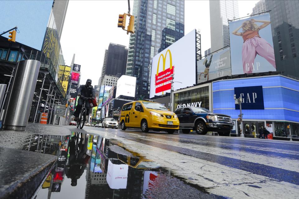 Cars and cyclists move through Times Square after a rain shower during the coronavirus pandemic, Saturday, May 23, 2020, in New York. (AP Photo/Frank Franklin II)