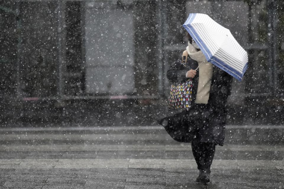 A person walks at a street in the snow Monday, Feb. 5, 2024, in Tokyo. Japan Meteorological Agency warns more metropolitan areas braced for snowfall Monday. (AP Photo/Eugene Hoshiko)