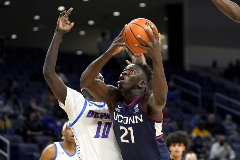 Connecticut's Adama Sanogo (21) looks to the basket as DePaul's Yor Anei defends during the first half of an NCAA college basketball game Saturday, Jan. 29, 2022, in Chicago. (AP Photo/Charles Rex Arbogast)