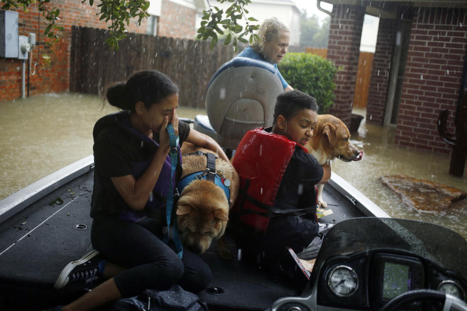 <p>A boy and girl hug their grandmothers’ dogs after being rescued from rising floodwaters due to Hurricane Harvey in Spring, Texas, on Monday, Aug. 28, 2017. (Photo: Luke Sharrett/Bloomberg via Getty Images) </p>