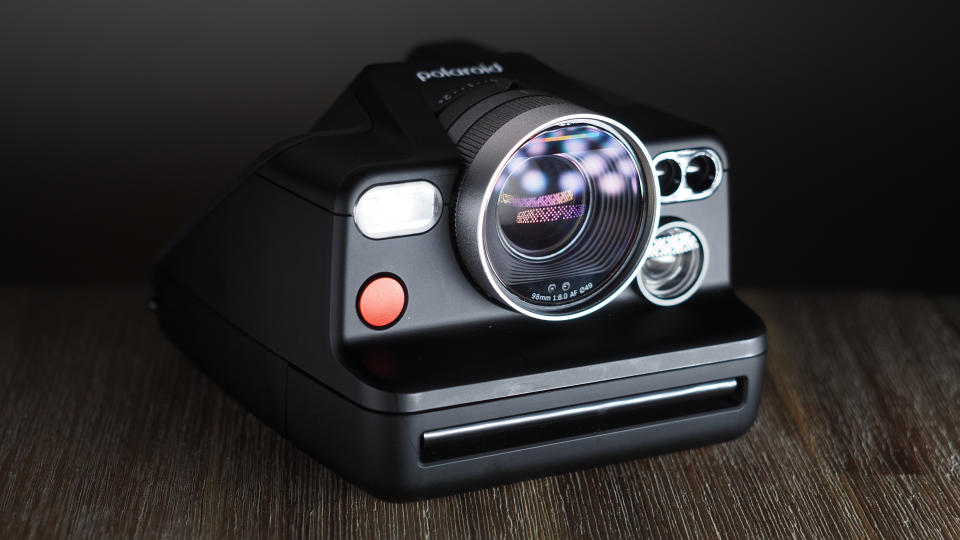 Polaroid I-2 camera on a wooden surface with dramatic lighting