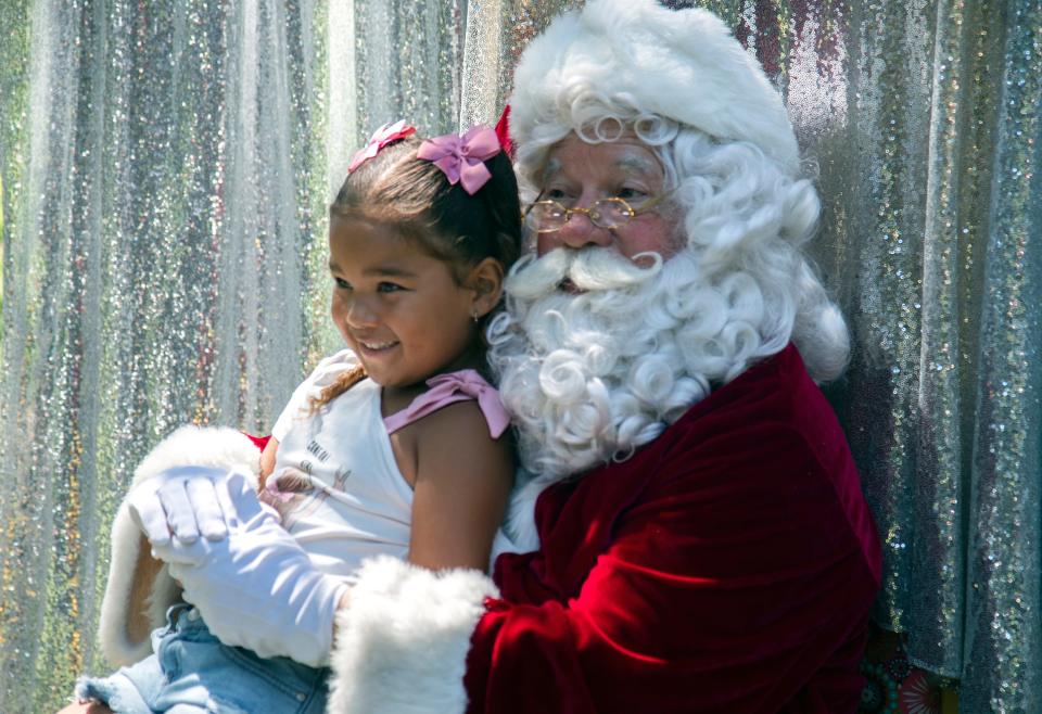 Charlie Thompson, 5, of Stockton sits on Santa's lap while posing for a picture at Pixie Woods' Christmas in July event in Stockton on Jul. 22, 2023. The the park is closed during the winter months and this event lets children celebrate the Yuletide at the park during summertime.