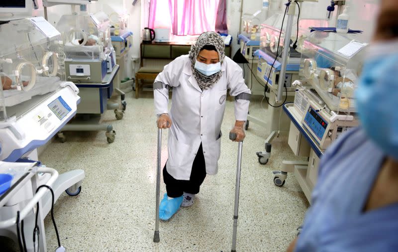 A nurse with a broken leg works in a room where premature babies are under control in incubators at a maternity hospital in Idlib