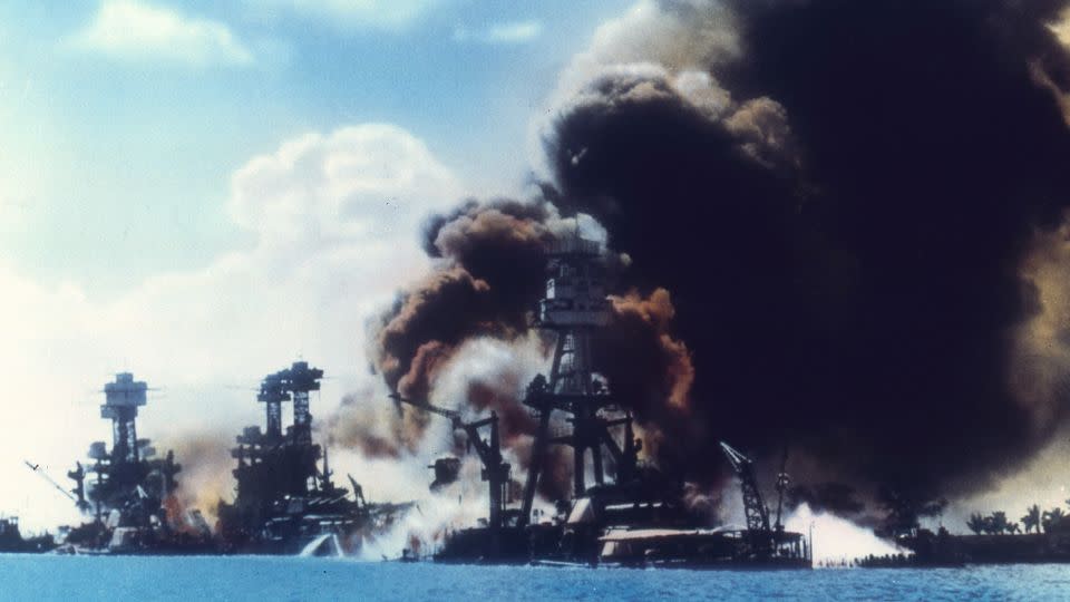 View of battleship row as explosions damage three American battleships during the Japanese attack on Pearl Harbor, Honolulu, Oahu, Hawaii, December 7, 1941. From left to right, the USS West Virginia, the USS Tennessee, and the USS Arizona. - US Navy/Interim Archives/Getty Images