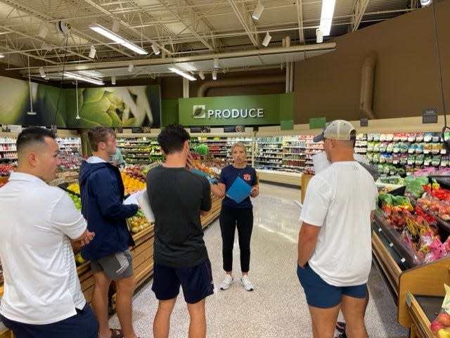 Allison Scherer, a dietician on the Auburn football coaching support staff, reviews nutritional guidelines with team members.